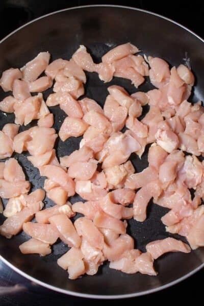 フライパンでカットされた鶏肉を示すプロセス画像 1。