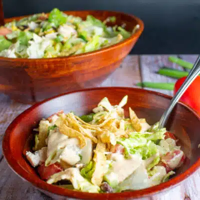 Square image of a Tex-Mex salad in a wooden bowl.