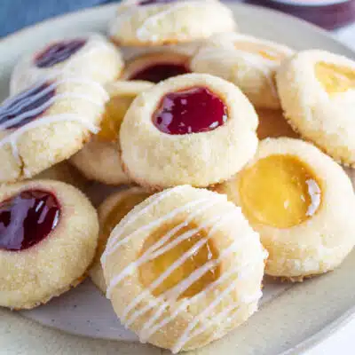 Square image of thumbprint cookies on a plate.