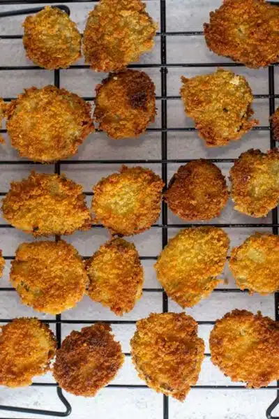 Process image showing fried pickles on wire rack.