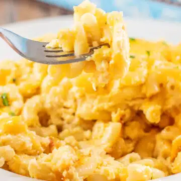 Wide closeup on a serving of Paula Deen's baked mac and cheese in a white pasta bowl.