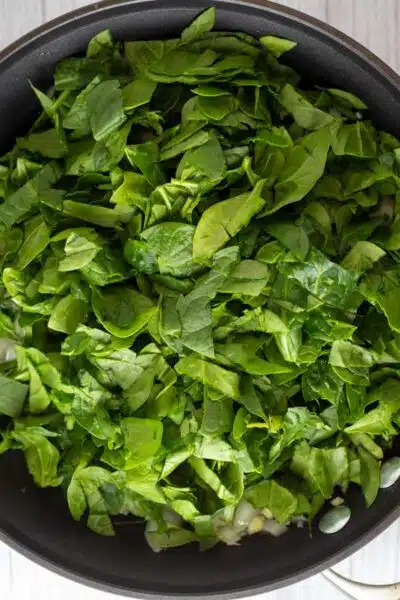 Process image 3 showing sauteing spinach.
