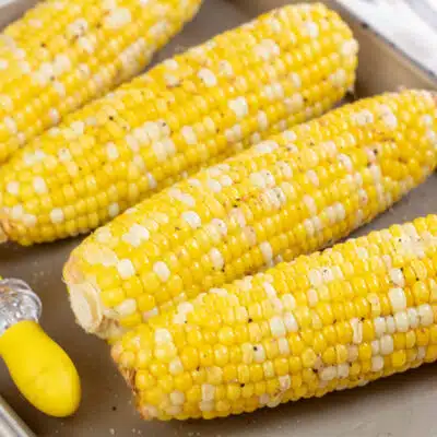 Square image of crockpot corn on the cob.