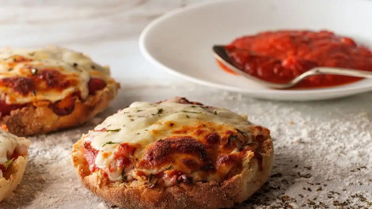 Wide image of English muffin pizzas.