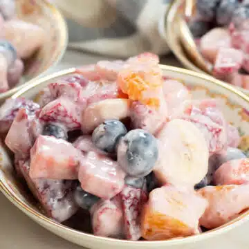Wide image showing Greek yogurt fruit salad.