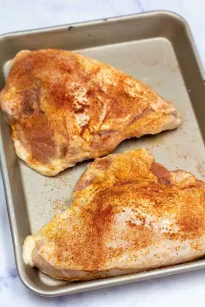 Process image 2 showing seasoned chicken breasts.