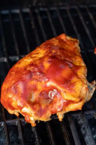 Process image 3 showing sauced and seasoned chicken breast on the grill.