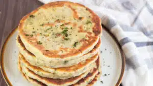 Wide image showing homemade flatbread stacked on a plate.