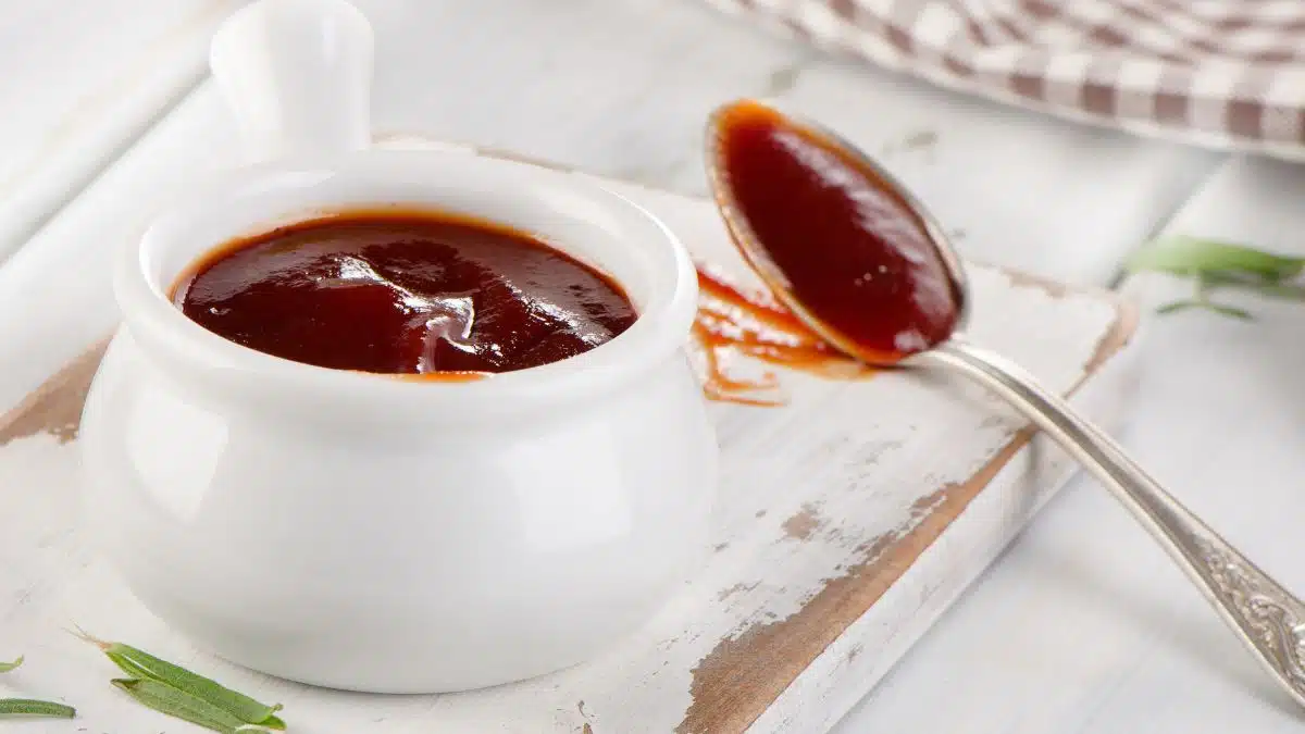 Wide image of honey bbq sauce in a small white bowl.