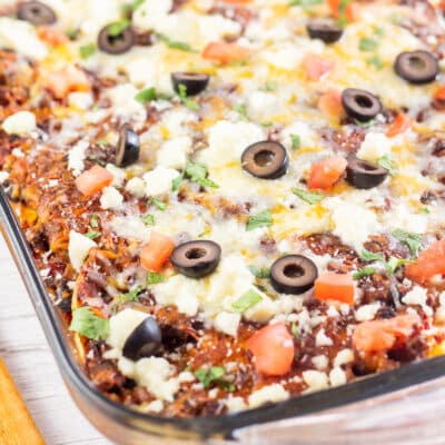 Square image of Mexican lasagna in a glass baking dish.