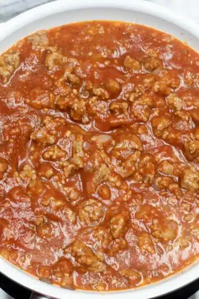 Process image 5 showing added tomato sauce and seasoning combined with meat.