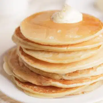 Wide image of a stack of pancakes made without eggs.