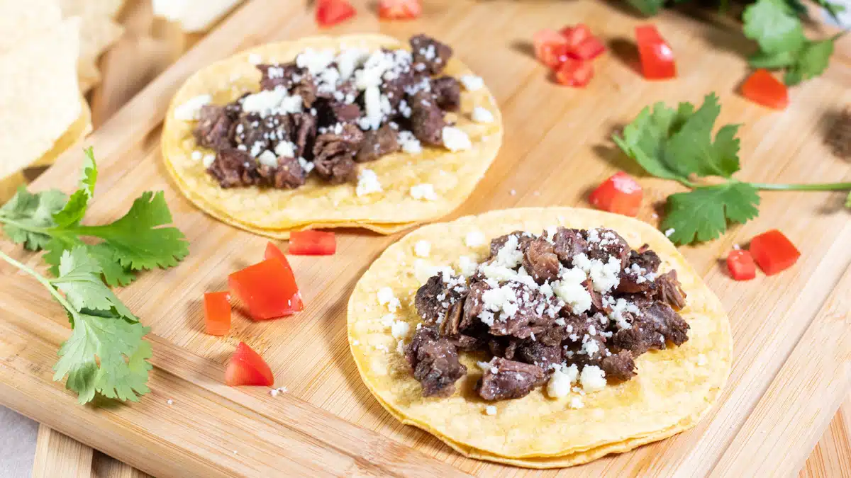 Wide image showing slow cooker beef cheek tacos.