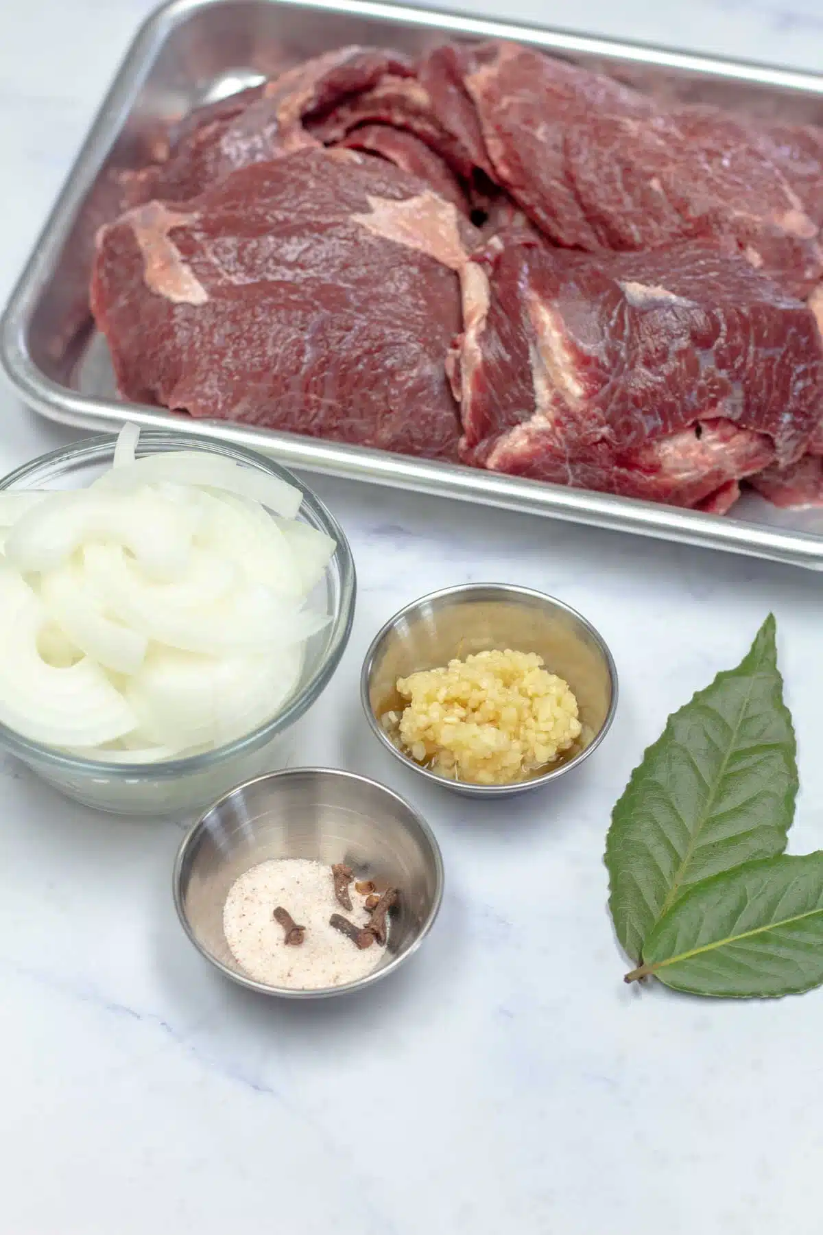 Tall image showing ingredients needed for slow cooker beef cheeks.