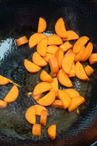 Process image 3 showing stir frying carrots.