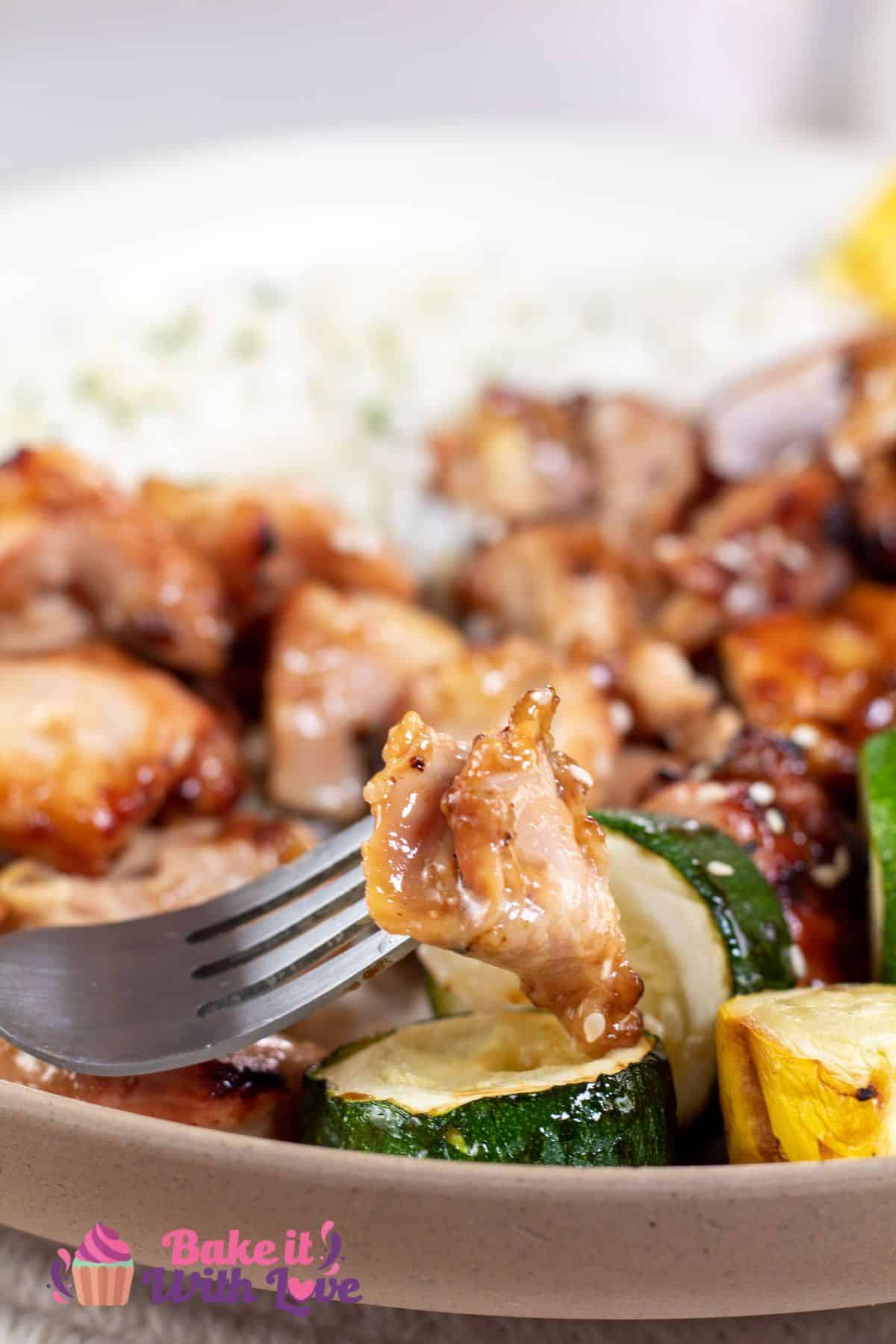 Tall image showing chicken teriyaki skewers on a plate with white rice.
