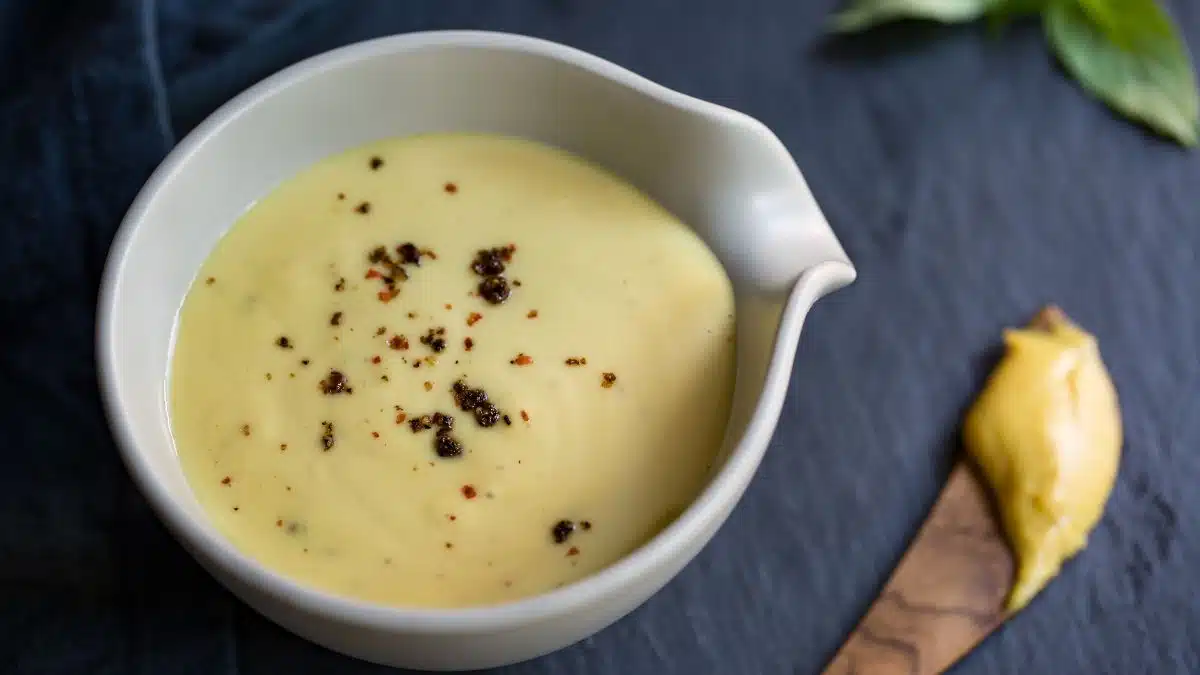 Wide image of honey mustard sauce in a white bowl.
