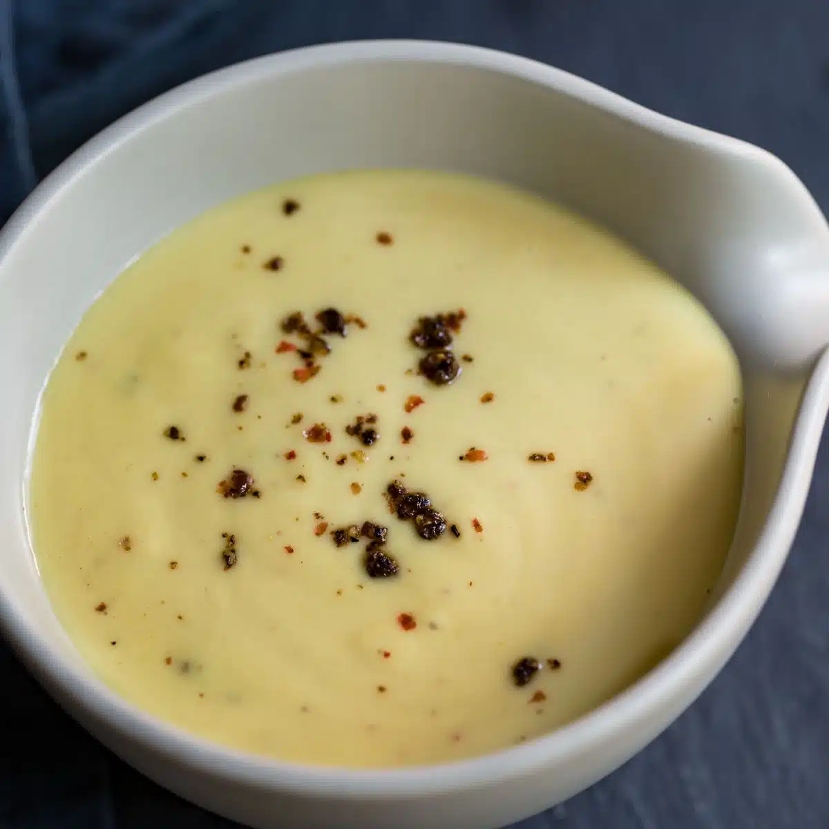 Square image of honey mustard sauce in a white bowl.