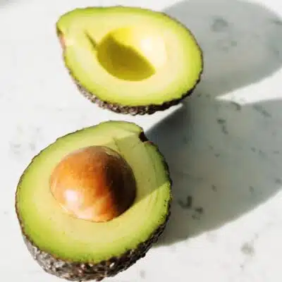 Square image of a split open avocado.