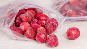 Wide image of frozen strawberries.