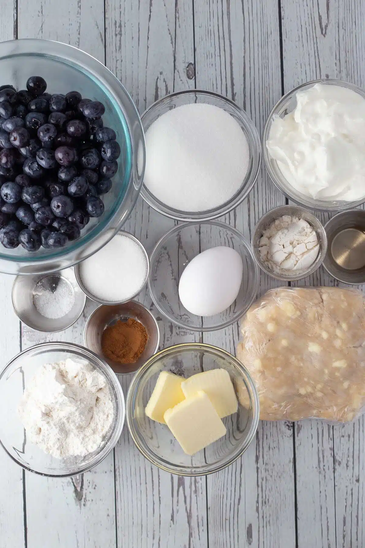Tall image showing ingredients needed for sour cream blueberry pie.