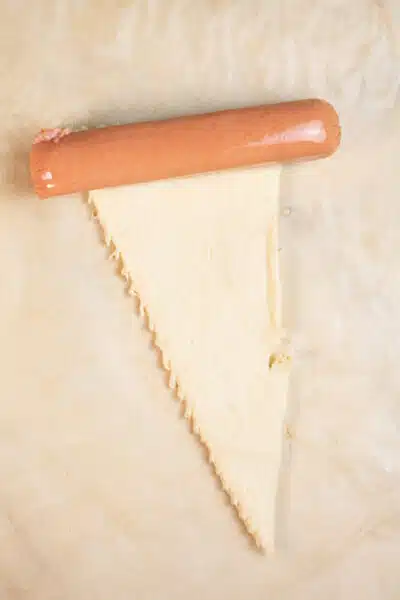 Process image 2 showing rolling hot dog in crescent roll dough.