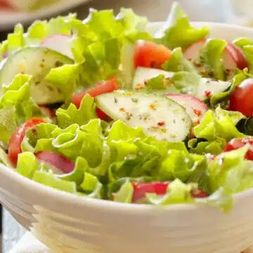 Wide image of a green garden salad.
