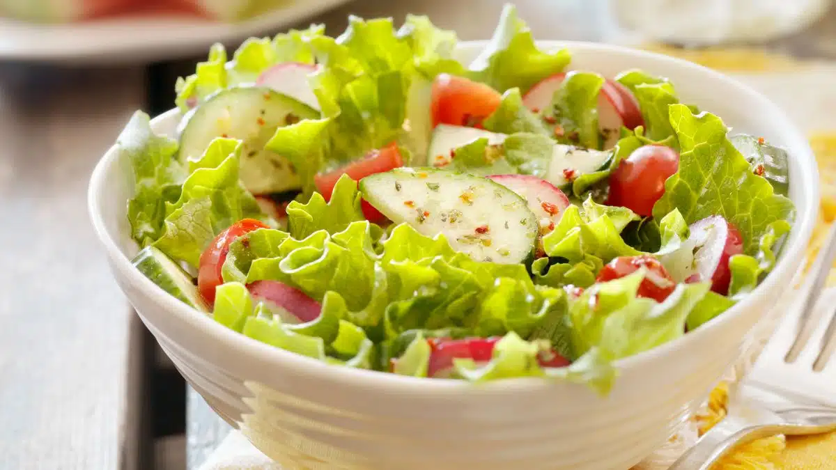 Wide image of a green garden salad.
