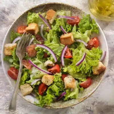 Square overhead image of a green garden salad.