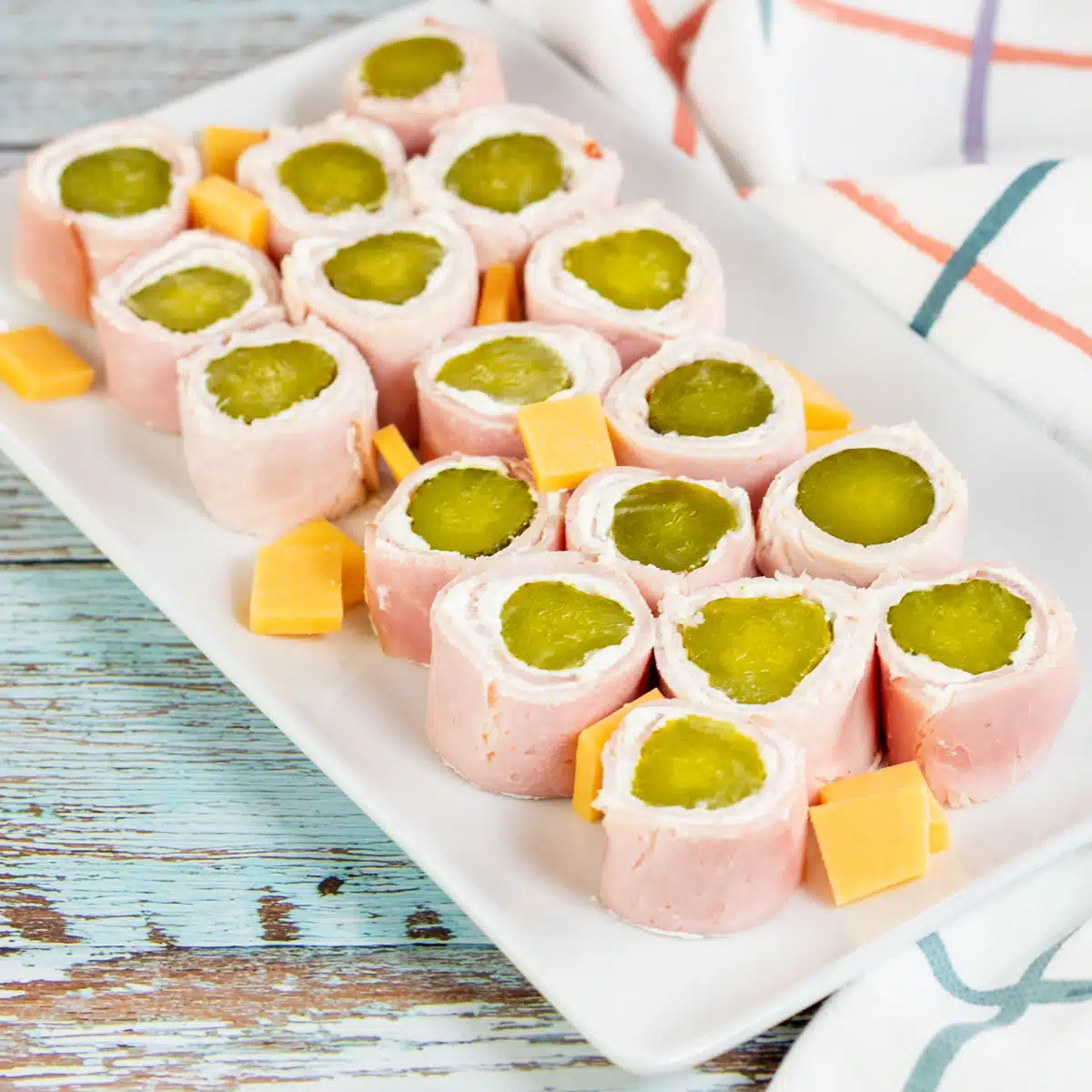 Square image of pickle roll up appetizers.