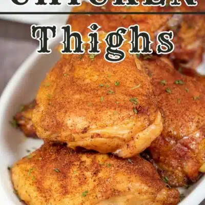 Pin image with text of smoked bone in chicken thighs on a white serving plate.