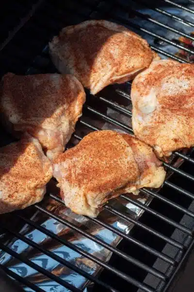 Process image 2 showing seasoned chicken thighs in the smoker.