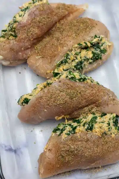 Process image 6 showing filled chicken breasts and seasoning ready to bake.