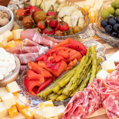 Square image of antipasto platter, with mostly mixes of cheese and meat.