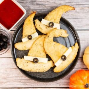 Square image of 4 crescent roll witches hats on a plate.