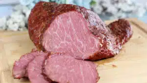Wide image showing smoked corned beef on a cutting board.