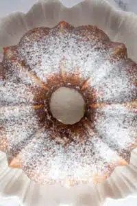 Process image 15 showing cake on serving dish with powdered sugar.