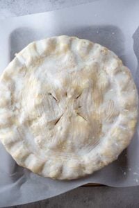 Gambar proses 7 menunjukkan bagian atas kulit pie yang diolesi susu sebelum dipanggang.