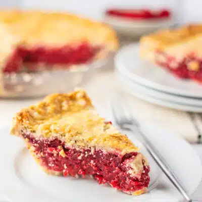 Square image of raspberry pie sliced.