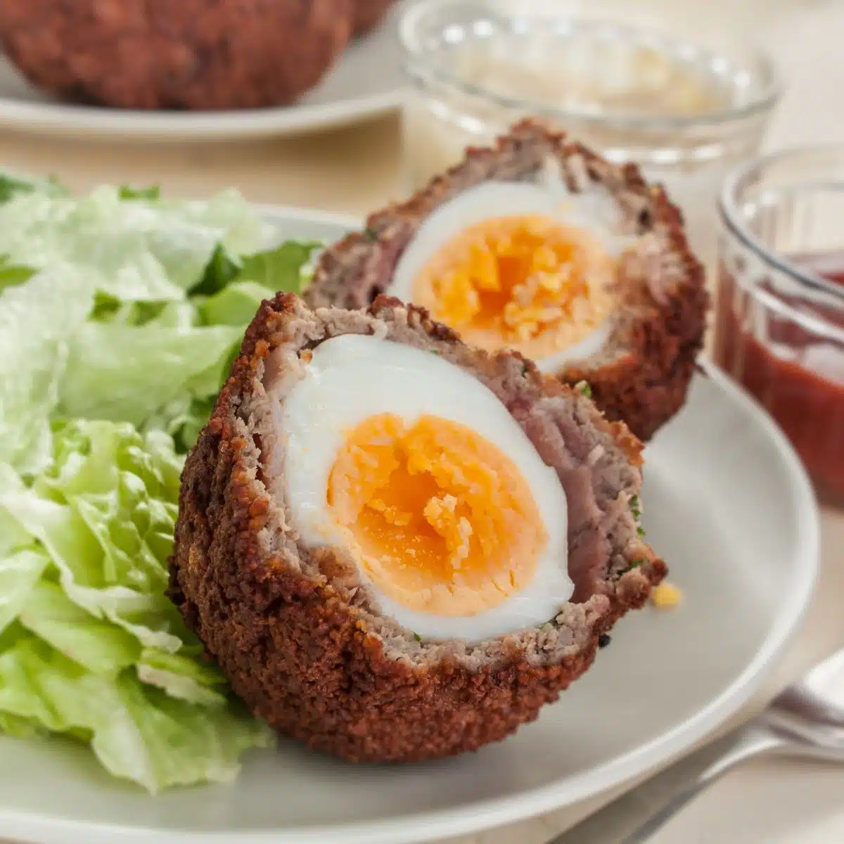 Square image of baked scotch eggs.