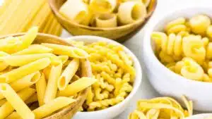 Wide image showing different types of pasta that could be used for macaroni and cheese.