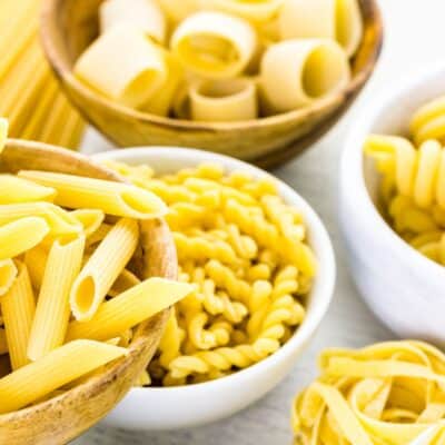 Imagen cuadrada que muestra diferentes tipos de pasta que podrían usarse para macarrones con queso.