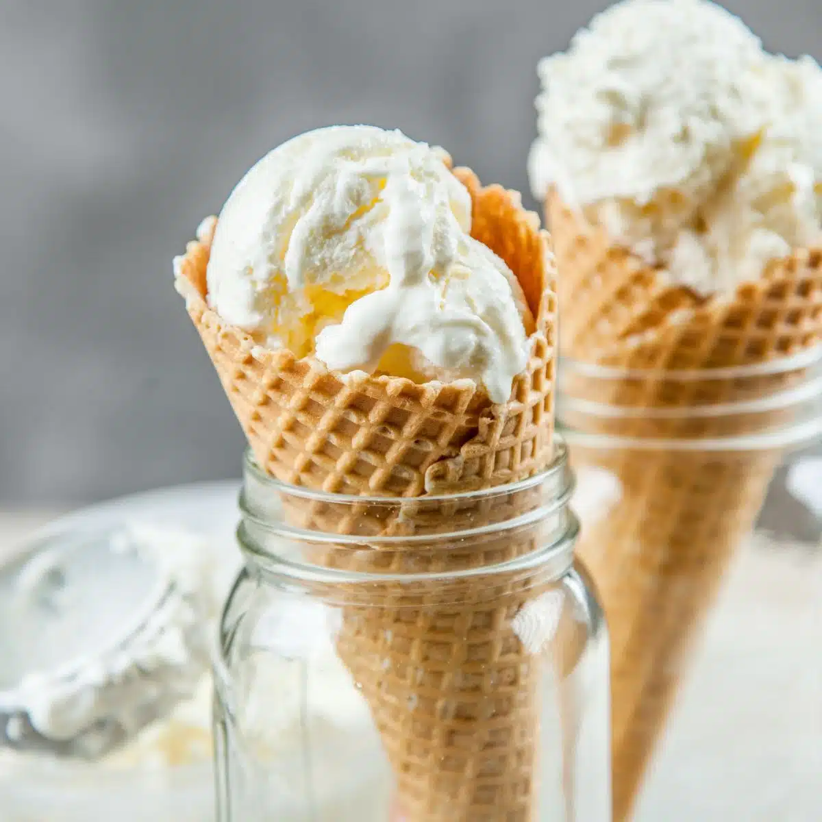 Čtvercový obrázek vanilkové zmrzliny bez stáčení v kornoutu zmrzliny.