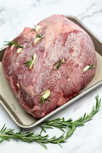 Process image 1 showing roast beef with seasoning, garlic, and rosemary.