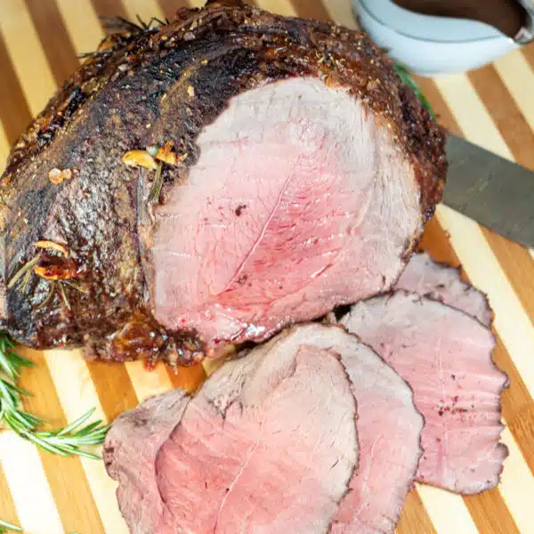 Square image showing sliced roast beef on a cutting board.