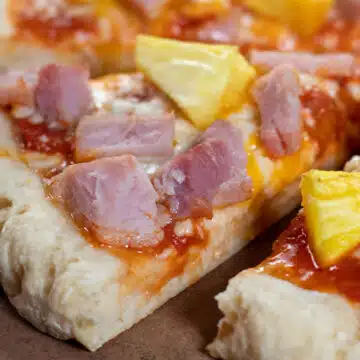 Wide image showing a Hawaiian style pizza made on a 2 ingredient pizza dough crust.