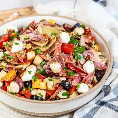 Best antipasto salad recipe to make shown in a large serving bowl on a light background.