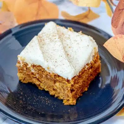Square image of pumpkin bars with cream cheese frosting.