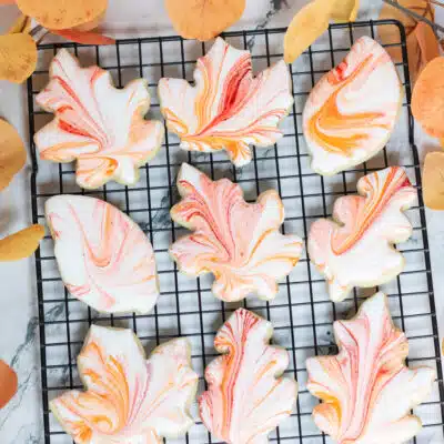 Easy tie dye fall leaves sugar cookies decorated with royal icing with red and orange ribbons of color.