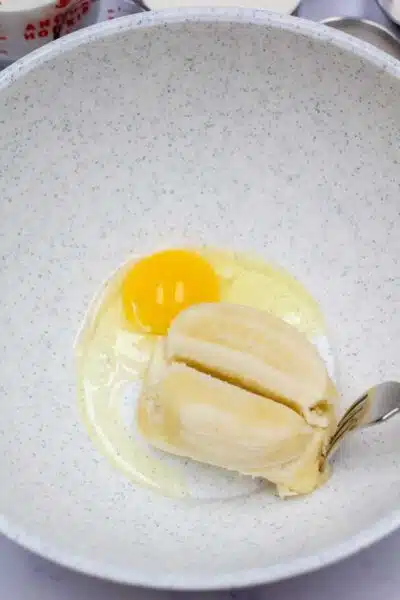 Process image 1 showing banana and egg in mixing bowl.